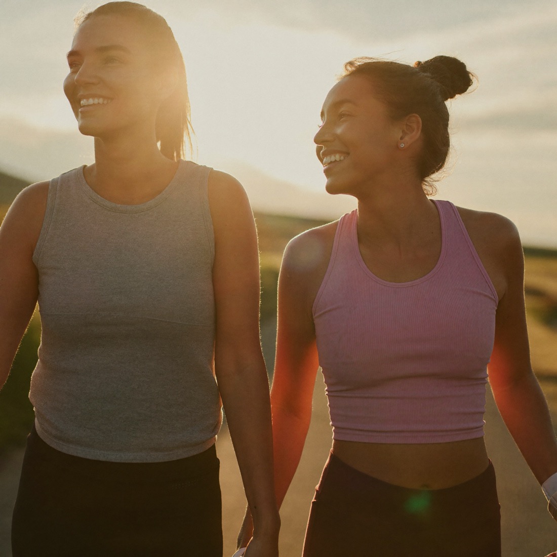Women walking together outdoors in soft golden evening light