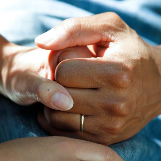 Two people holding hands in a moment of support and reassurance